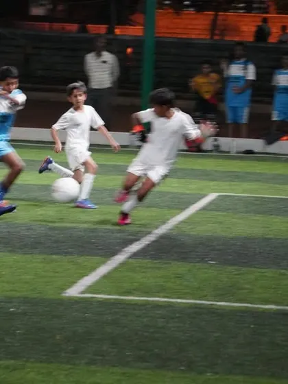 An intense moment as our player in blue dribbles past a defender in white during a practice match.