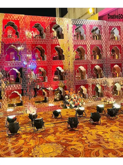 A different angle of the 'jharokha' photo wall, showcasing the detailed craftsmanship and the beautiful floral arrangements in each niche.