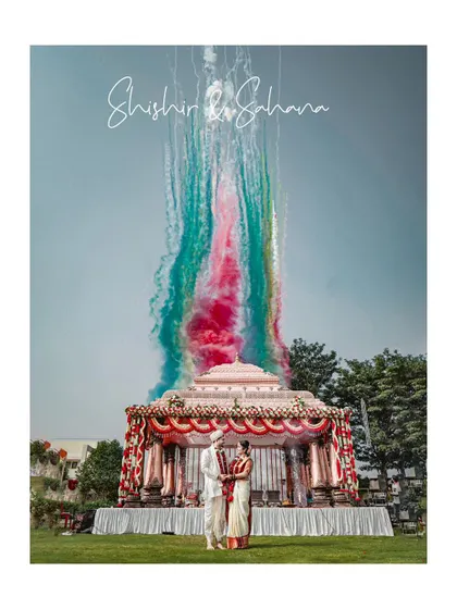 An absolutely epic shot of the couple under their wedding mandap, with colorful smoke creating a magical and unforgettable backdrop.