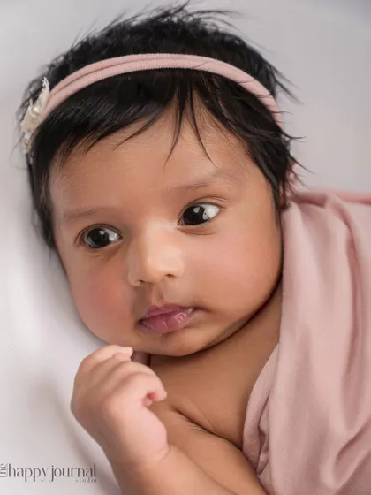 A close-up portrait capturing the beautiful, wide-eyed gaze of a newborn. These simple, unposed moments are just as precious and show the emerging personality of your little one.
