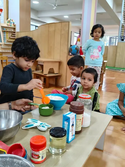 Measuring ingredients requires focus and precision. This young baker is concentrating hard as he contributes to the group's cake-making project.