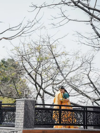 A quiet, romantic moment between the couple on a bridge during their Haldi day. It's a peaceful pause in the middle of a day of celebration.