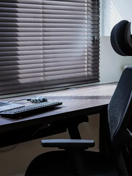 A close-up of the ergonomic workspace in the multi-use room, with a comfortable chair and ample desk space next to the window.