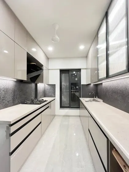 The parallel layout of the grey kitchen provides an efficient workspace, with plenty of counter space on both sides for meal preparation.