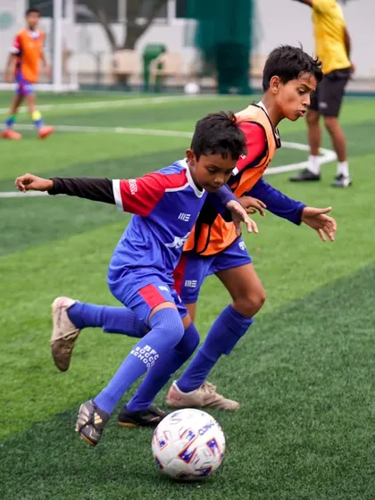 A player shields the ball from a challenger. Learning to protect the ball under pressure is a vital skill we teach at all age levels.