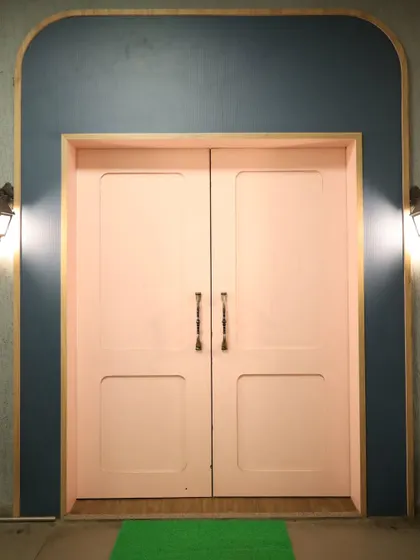 The charming entrance to our creative space. The pink doors and warm lighting offer a welcoming vibe for all artists.