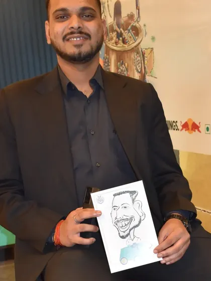 A young professional with his caricature, a fun memento from a work event.