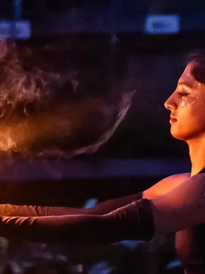 A moment of stillness and connection with the flame before the dance begins. This shot captures the calm focus required for fire spinning, a practice that is both meditative and exhilarating.