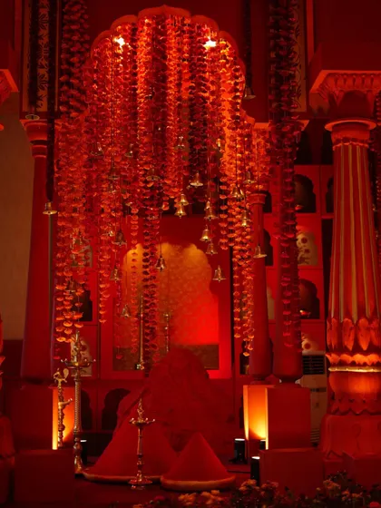 A detail shot of the 'Lal Bagh' mandap, showing the intricate red pillars and cascading floral decorations.