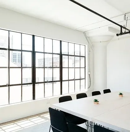 A bright and minimalist commercial meeting room. I provide professional painting services for offices and businesses, creating clean, productive environments with a crisp white finish.