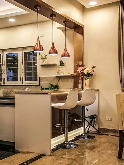 Warm and inviting, this kitchen features a simple breakfast bar illuminated by stylish copper pendant lights. It serves as a cozy transition between the kitchen and the main living space, perfect for entertaining guests while you cook.