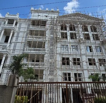 A site photo of the Sikaria project in Guwahati, still under construction. The intricate classical details, columns, and balconies are already taking shape, showing the design's complexity.