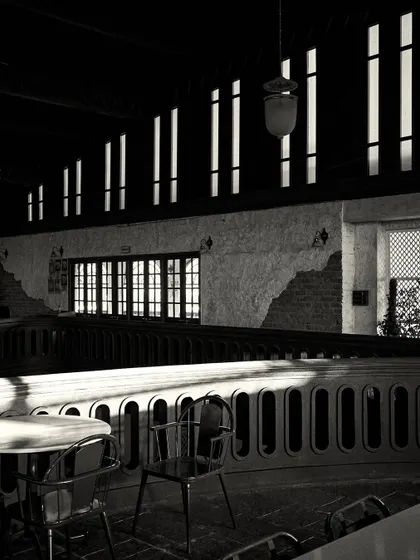 Another view of the dramatic shadows cast by the windows, creating a rhythmic pattern of light on the balcony railing.