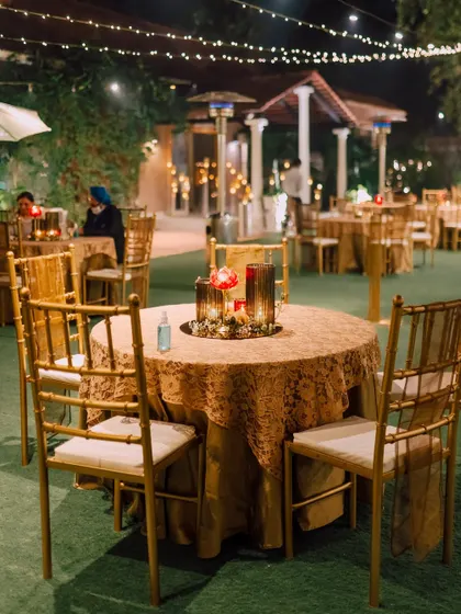 A classic round table setup with a golden tablecloth and a simple candle centerpiece, exuding timeless elegance.