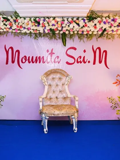A customized floral decoration for Moumita's ear-piercing ceremony. The soft pink backdrop is framed with a beautiful arch of fresh flowers, creating a delicate and celebratory setting.