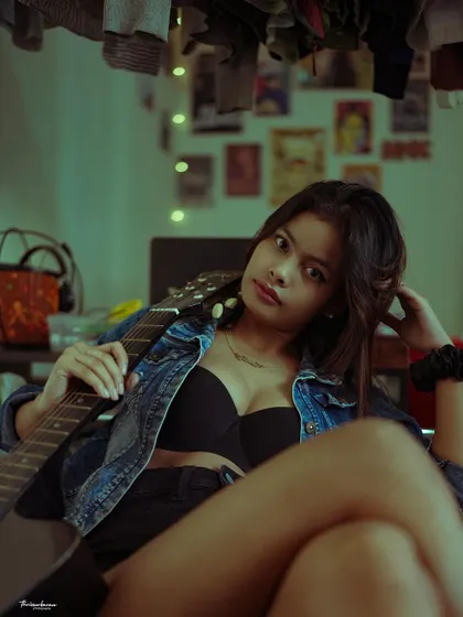 This shot shows the full context of the lifestyle portrait, with posters and clothes in the background adding to the personal, lived-in feel.