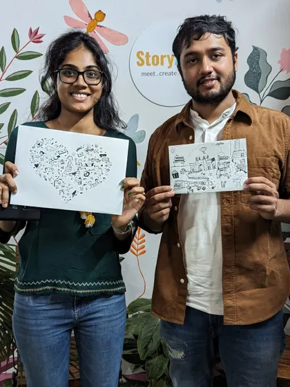 Two friends proudly displaying their doodle art, one with a heart full of doodles and the other with a page of travel memories.