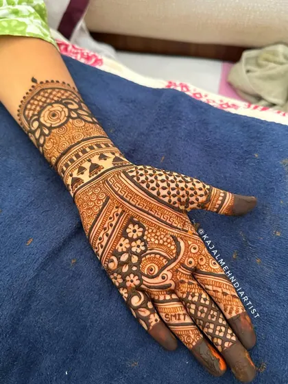 A full hand of intricate Indian henna. This design is packed with detail, including personalized name art on the finger, making it a truly special piece for the bride.