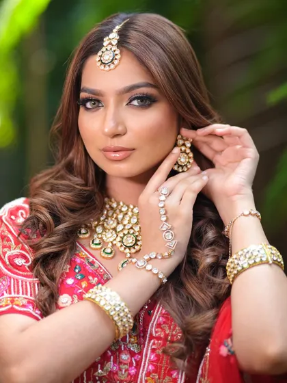 A detailed shot of the bride's hands, adorned with hathphool and bangles that perfectly match her red lehenga and kundan jewellery set.