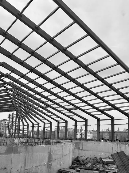 "Roof Likes To Swing": A series of black and white photos tracking the progress of a large-scale steel roof structure for an experience center in Chennai.