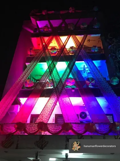 The same house exterior, but with a different lighting concept. We used multi-colored lights to project onto the drapes, creating a dynamic and festive look perfect for a sangeet or a birthday party.