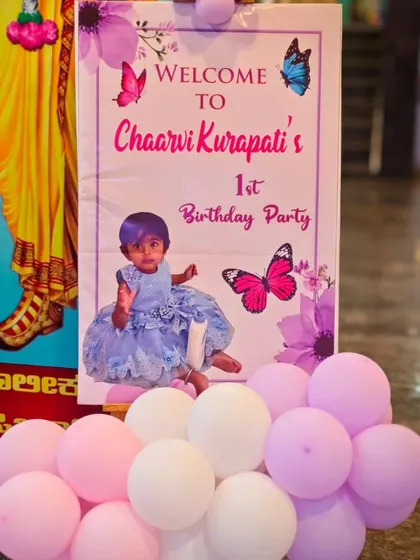 A personalized welcome sign for Chaarvi's first birthday party, decorated with butterfly graphics.