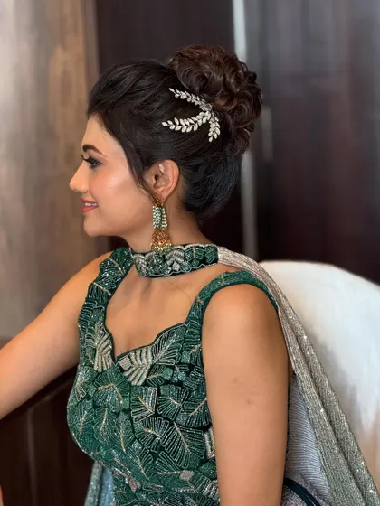 A smiling model showing off the elegant messy bun. This style is versatile and suits many different face shapes and outfits.