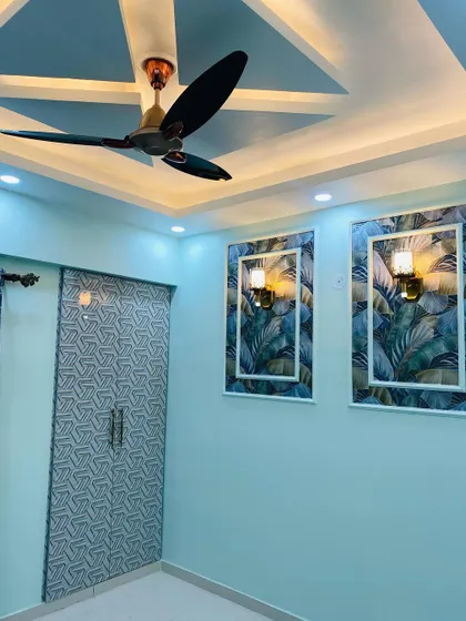 A bedroom with a cool blue color scheme. The wardrobe has a geometric 3D pattern, and the wall features panels with tropical wallpaper.