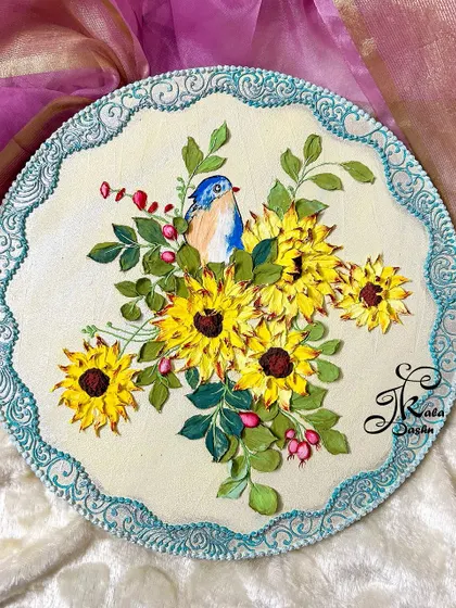 A 10-inch circular wall plate featuring a cheerful bouquet of sculpted sunflowers with a small bluebird perched among them.