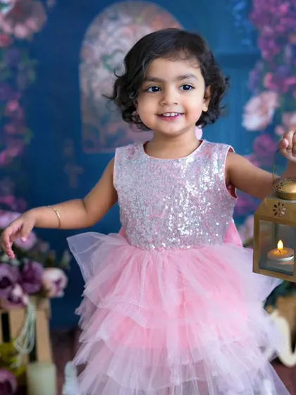 A little princess holding a lantern. This two-year-old girl's sweet smile and sparkling dress make for a magical portrait.