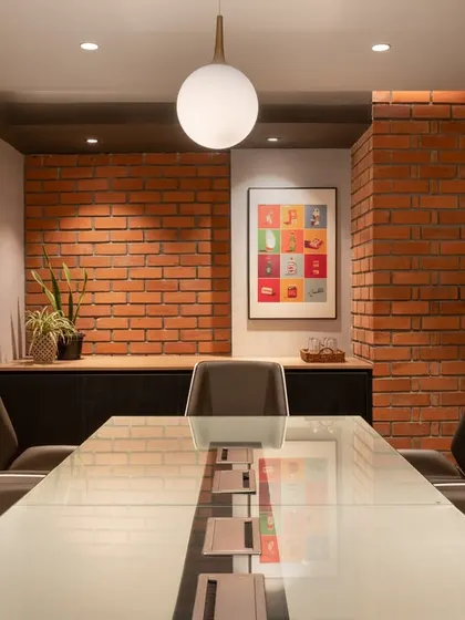 The main conference room at YOUNION Office features an exposed brick wall and modern leather chairs, blending an industrial aesthetic with corporate professionalism.