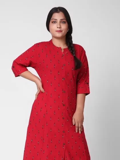 This is a mid-length shot of a plus-size model wearing a red printed cotton kurti. The clean background and simple pose are standard for ethnic wear e-commerce, focusing on the garment's fit and pattern.