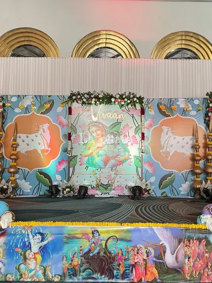 The main stage for a Krishna-themed party, featuring beautiful illustrations of Lord Krishna and the sacred cows. The stage front was decorated with a colorful panel depicting scenes from Krishna's life.