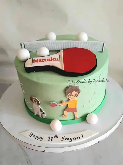 A fun cake for a table tennis lover's 11th birthday. The design features a paddle, net, and ping pong balls.
