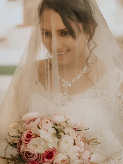 A lovely, soft portrait of the bride smiling from behind her veil, capturing her happiness and anticipation.