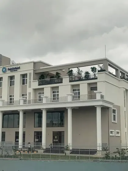 An angled perspective of the EuroSchool building, showing the depth of the facade and the rooftop terrace area.