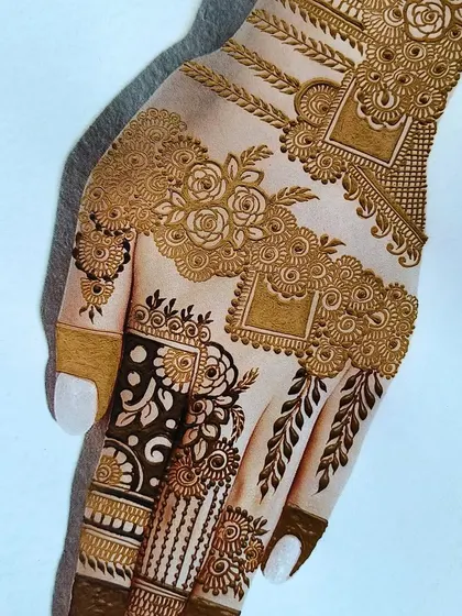 A close-up of a beautiful and complex hand design. This showcases a mix of floral patterns, geometric shapes, and leafy vines, demonstrating how to combine different textures for a rich look.