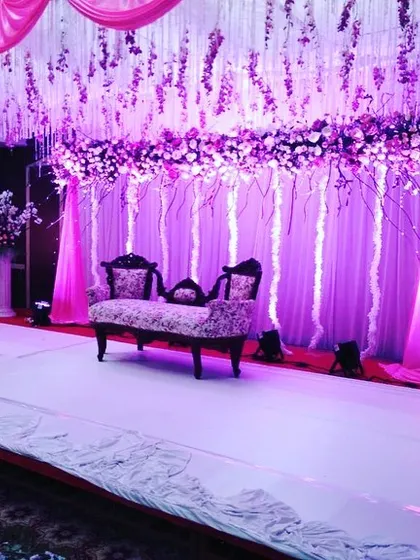 This angle shows the full effect of the hanging floral installation and stage lighting. This type of custom stage design transforms a venue into an immersive, thematic experience.
