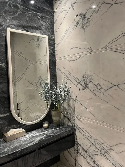 We translated timeless Art Deco vibes into this stunning washroom. Bold black and white marble create a striking aesthetic defined by symmetry, contrast, and elegance.