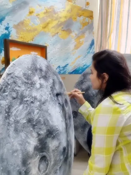 Working on the fine details of a textured moon mural. The process of building up layers to create the moon's surface is both meditative and deeply satisfying.