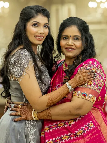 A heartwarming moment between the bride and her mother, both adorned with beautiful mehendi. It's a celebration for the whole family.