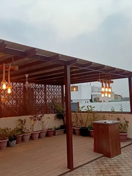 I can transform large terraces into functional outdoor living rooms. For this project, I designed and installed a custom wooden pergola to create a shaded seating and entertainment area, complete with rustic rope lighting and a dedicated bar space.