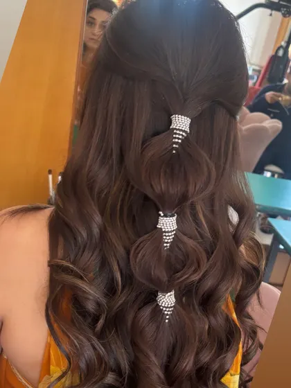 A modern take on a half-up style, this look features a bubble ponytail effect created with sparkling crystal cuffs. This is a trendy and glamorous option for a cocktail party or reception.