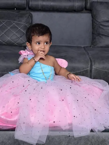 Hey princess. This little one looks like a butterfly in her custom pink and blue frock with a sparkling tulle skirt.