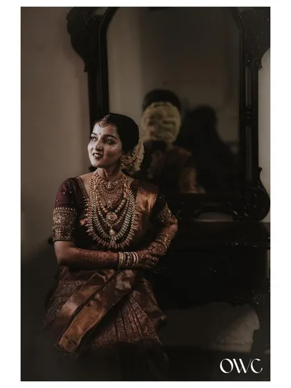 A moody and classic portrait of the bride sitting by a vintage mirror.
