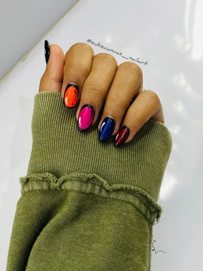 A fun and unique comic book or pop art nail design. Each nail is painted with a vibrant color and outlined in black to create a 2D cartoon effect.