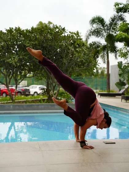 Practicing Eka Pada Koundinyasana I by the pool. Arm balances require presence and focus, no matter the setting.