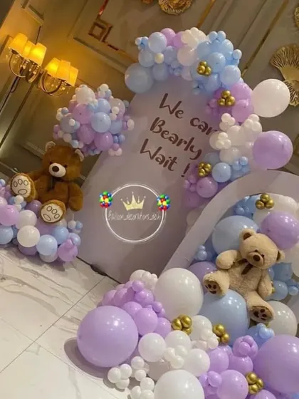 A dreamy teddy bear baby shower theme in pastel purple, blue, and white. This "We Can Bearly Wait" setup features two arches and teddy bears nestled in balloon clouds.