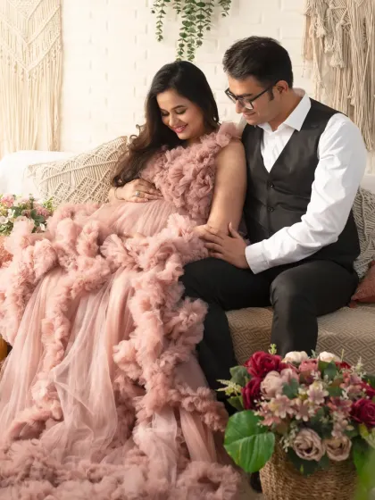 A cozy and loving moment. The couple shares a quiet connection on our boho-themed set, surrounded by soft textures and floral arrangements.