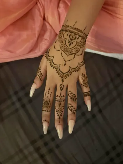 A very popular Gen-Z design. This stylish back-hand mehndi features a hanging jewel-like pattern that is both modern and chic.